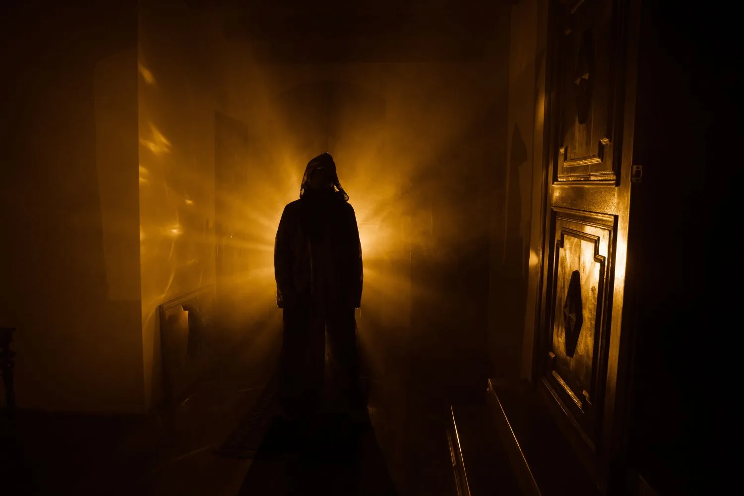 Ghostly figure in front of orange light in old hallway