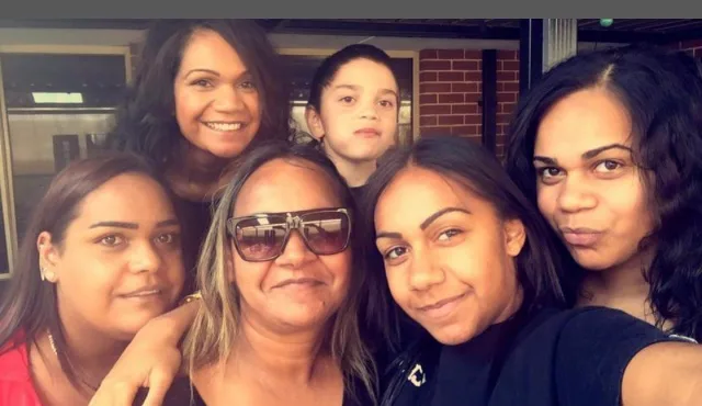 Four women and one young boy all smilling at camera.
