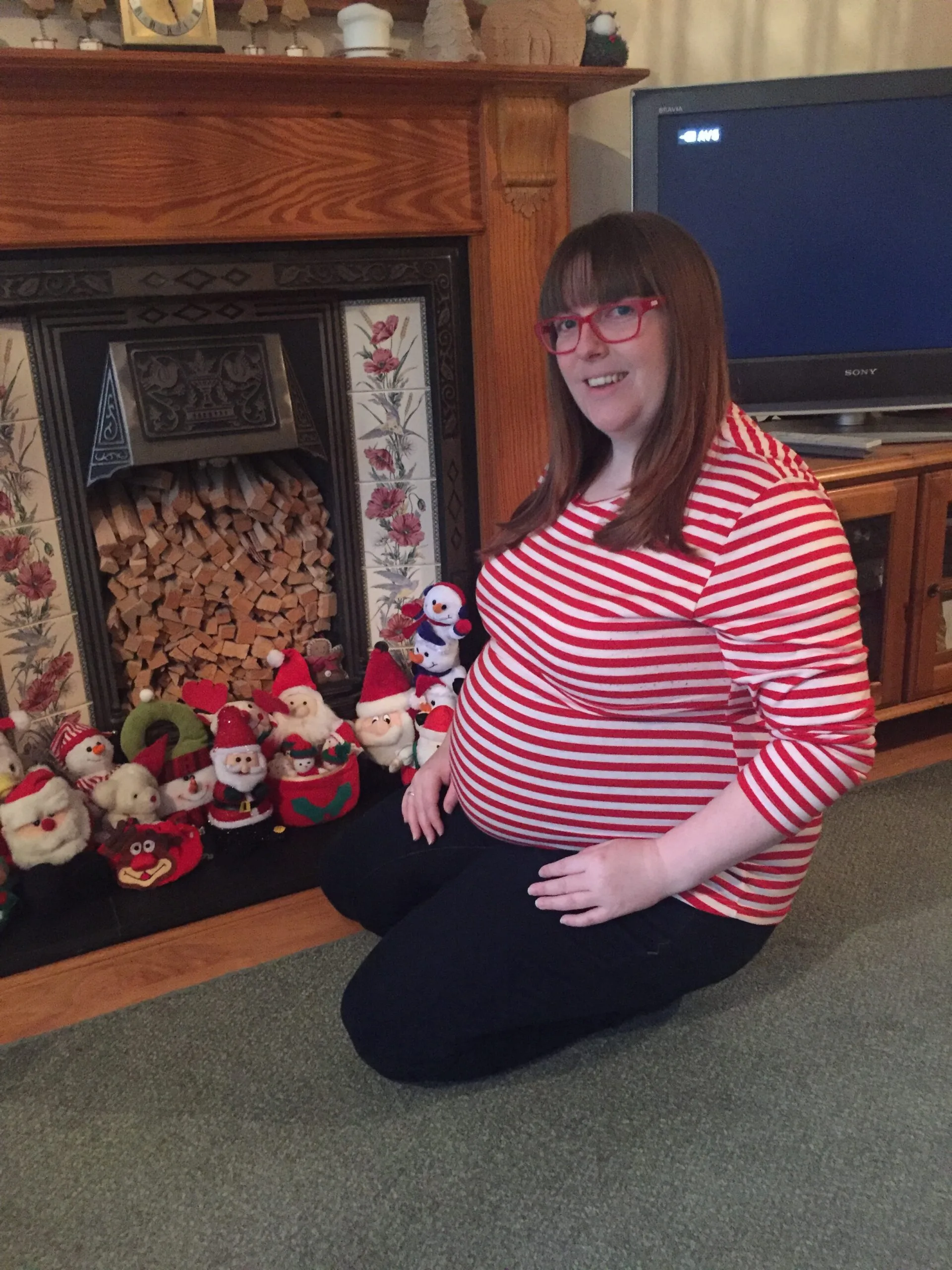 woman in red and white striped shirt with pregnant belly 