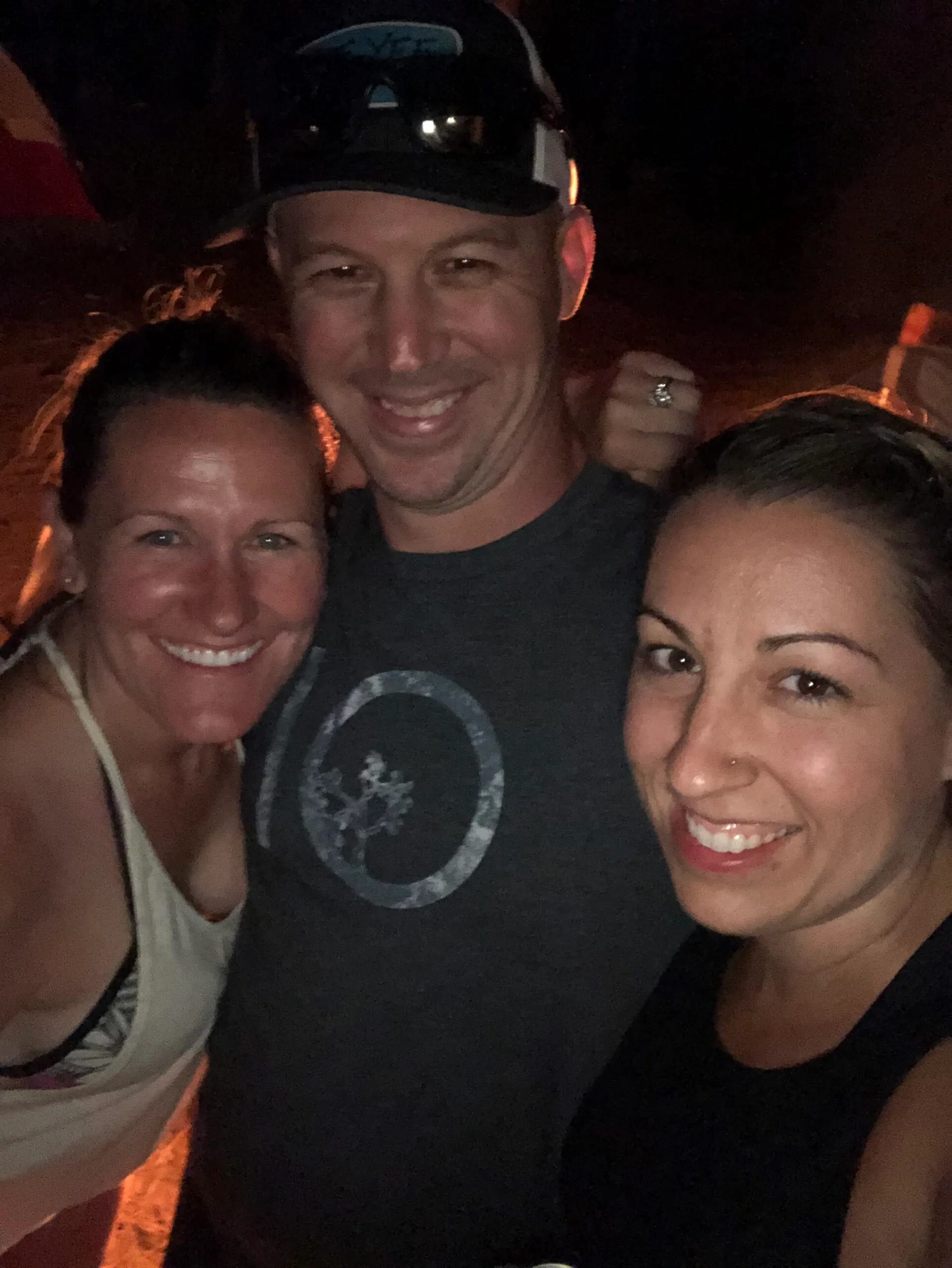 Image of Husband, wife and friend standing in front of campfire