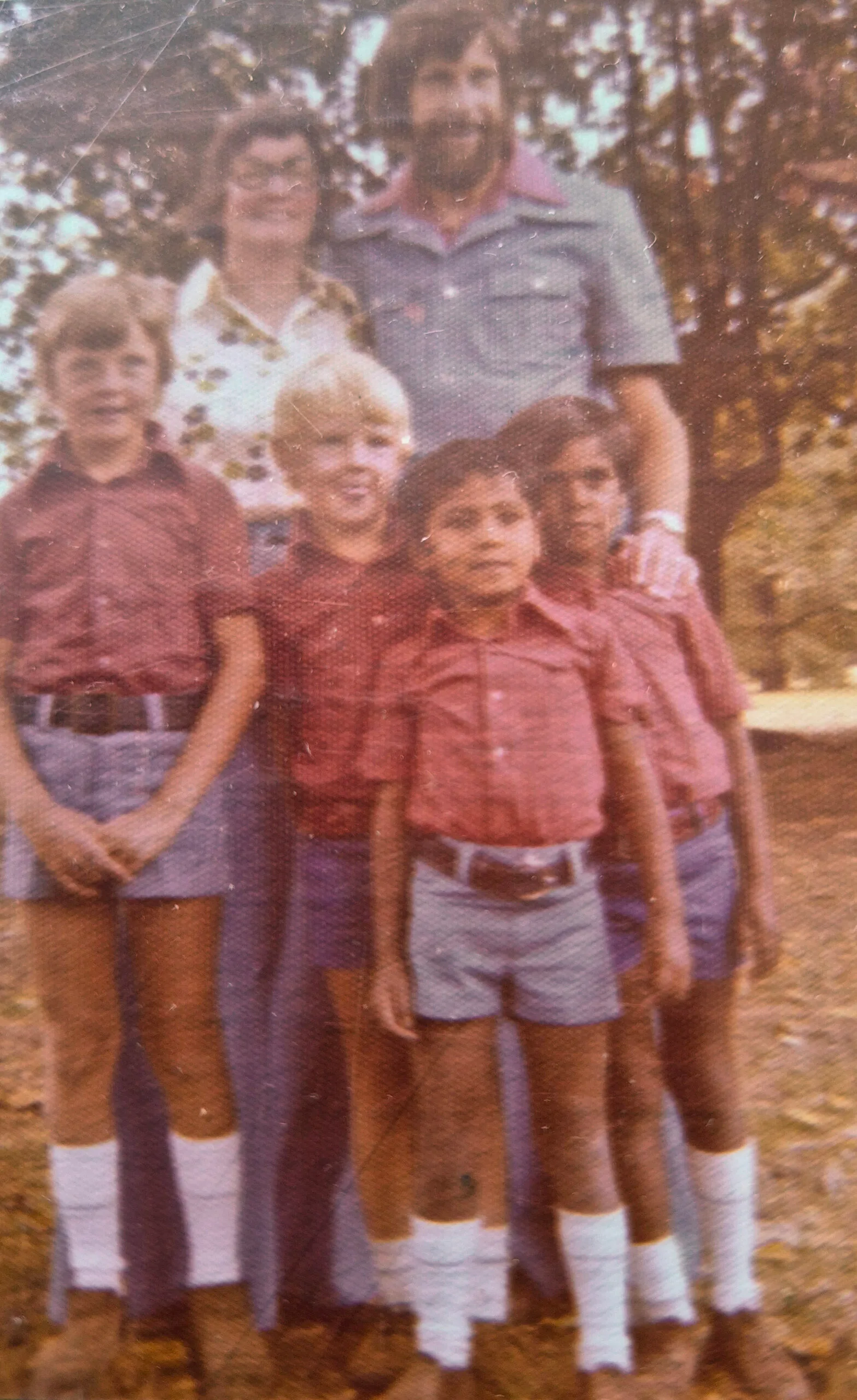 Man and woman standing behind four little boys. All smilling at camera.