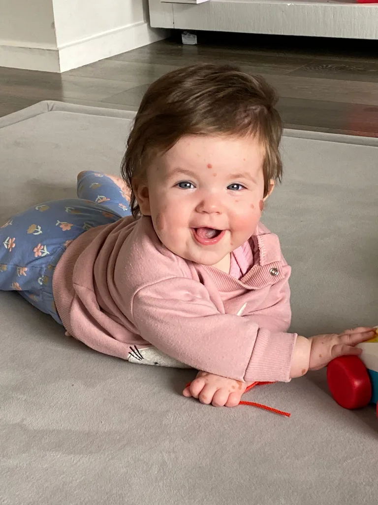 Baby Livi smiling on the floor