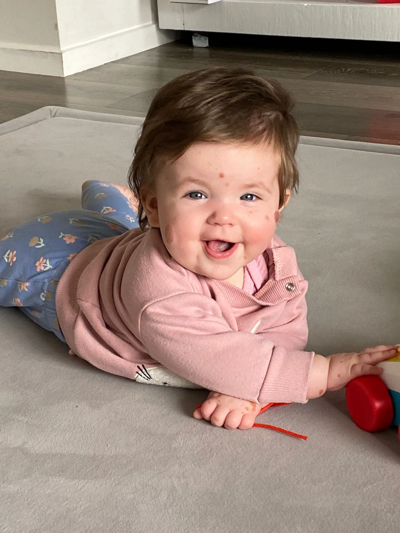 Baby Livi smiling on the floor