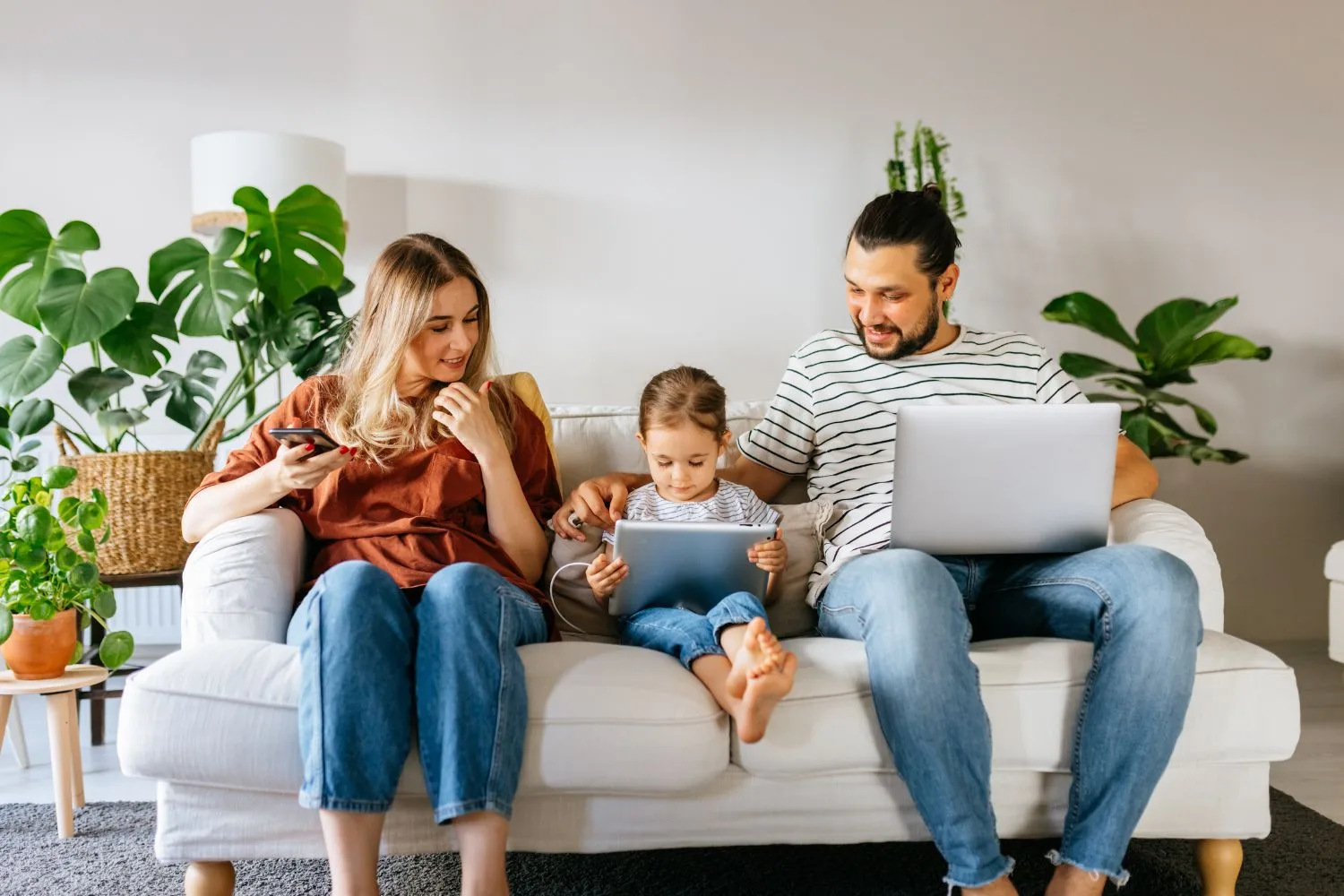 Familes on sofa using devices