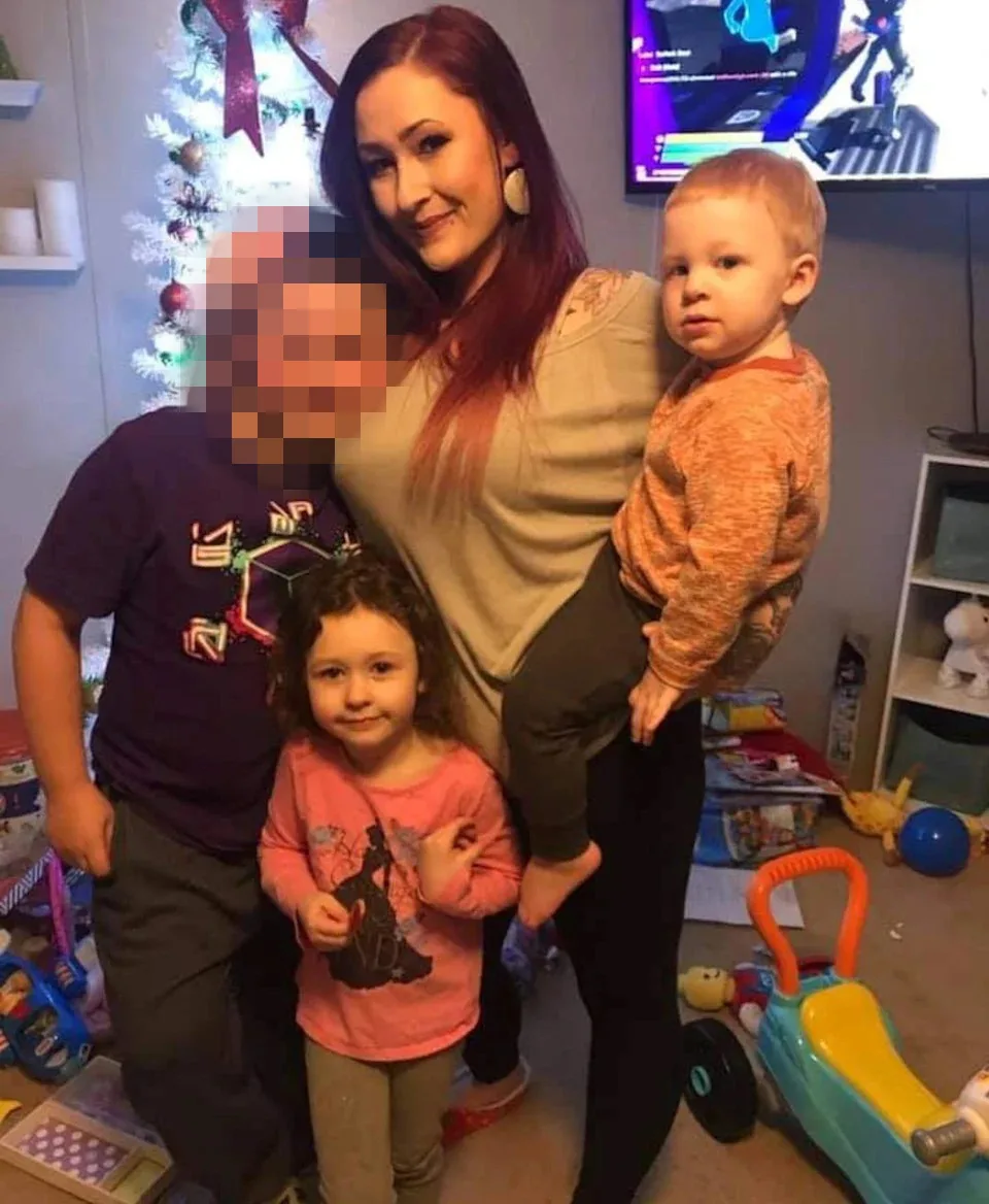 family photo of mother and kids surronded by toys