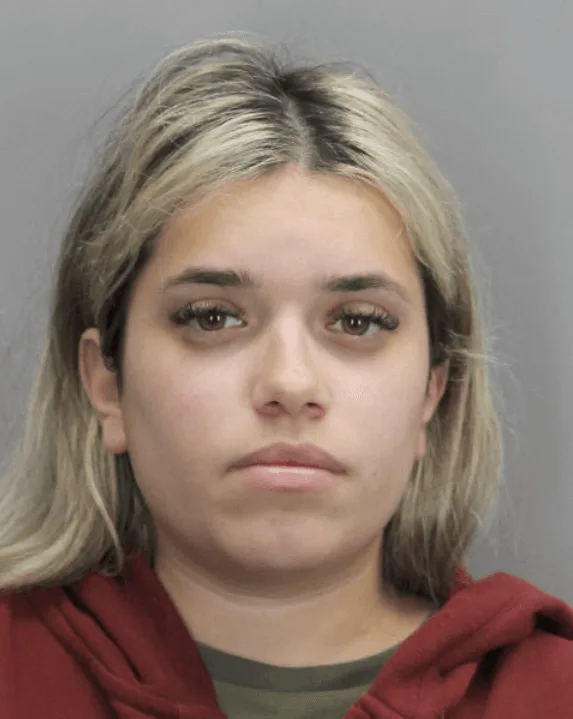 Mugshot of woman wearing red hoodie.