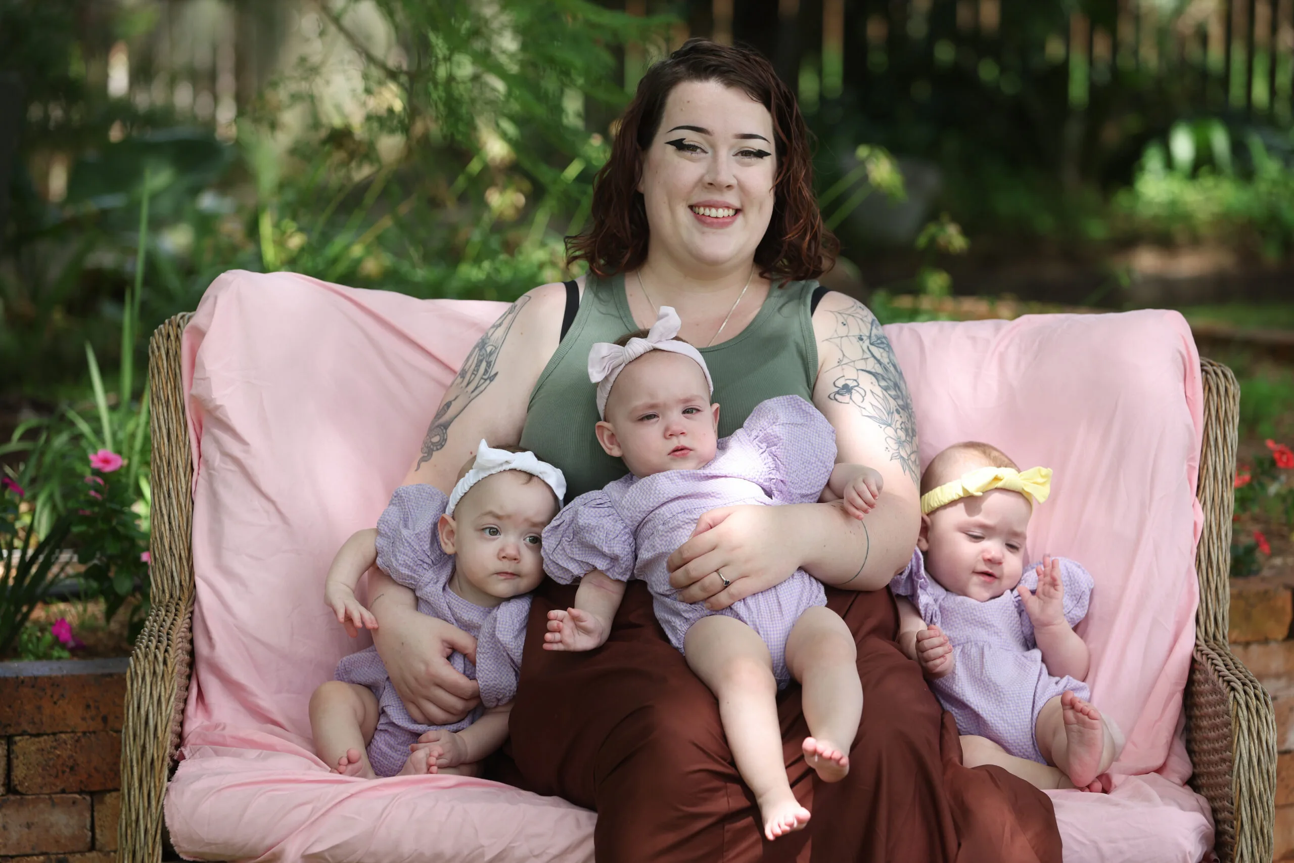 a woman with three babies on couch