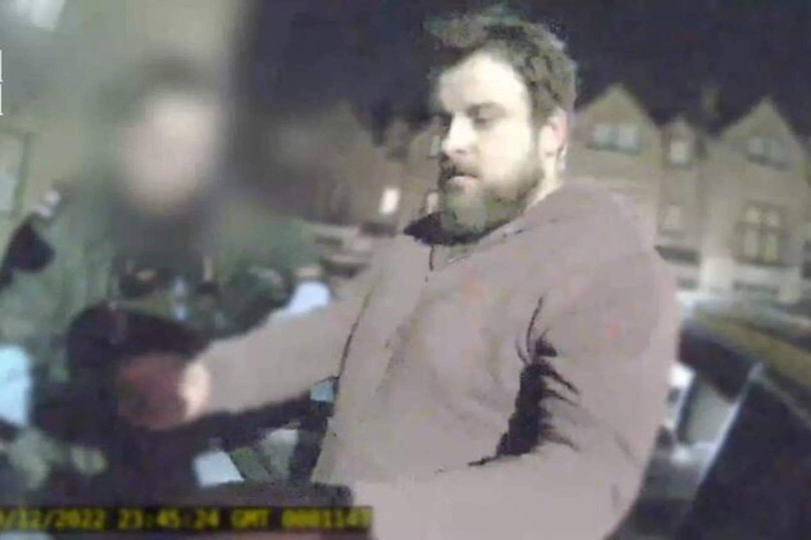 Footage of man wearing brown hoodie being arrested.
