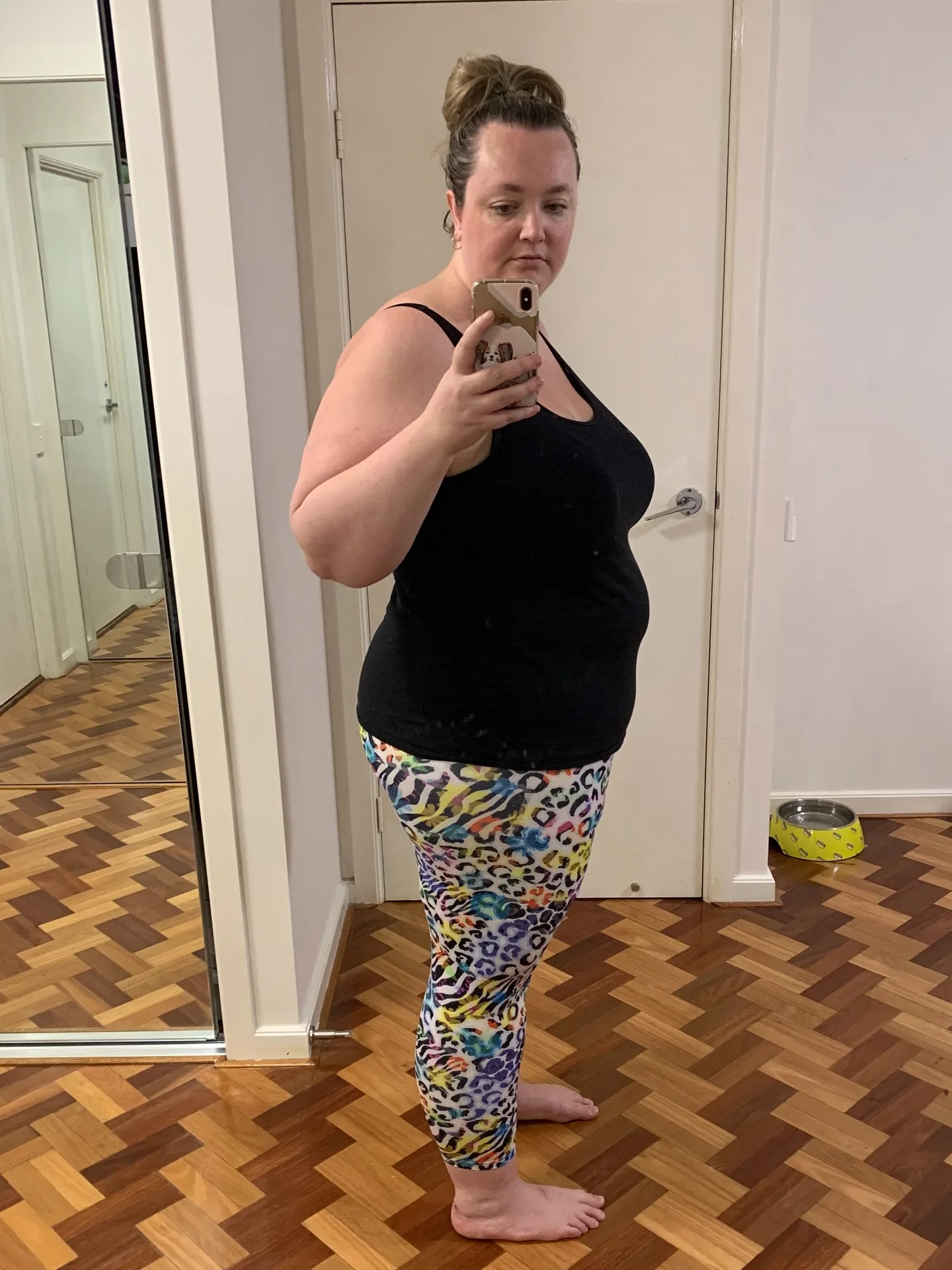 Woman in gym clothes taking mirror selfie