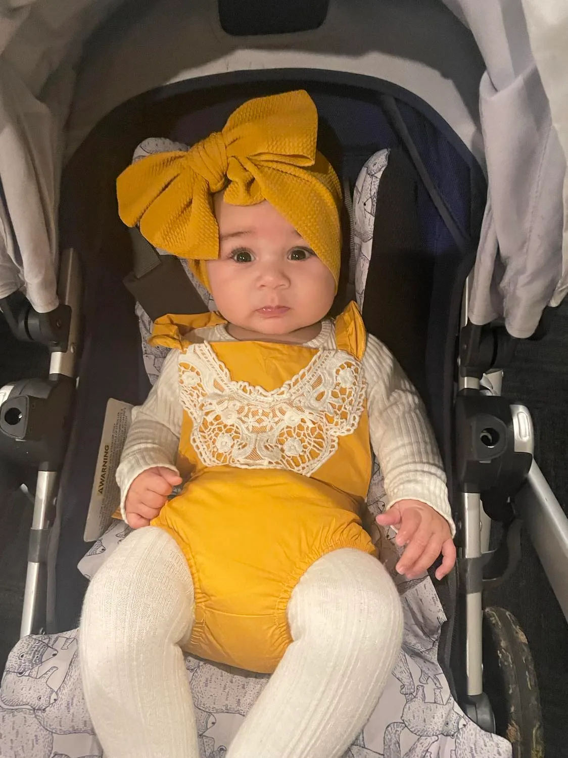 Image of newborn bub dressed in mustard yellow outfit