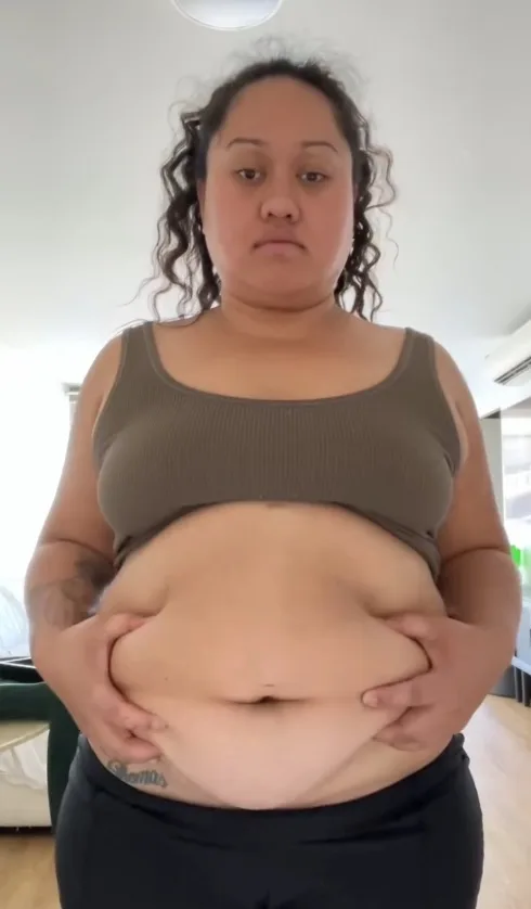 woman looking sad holding her belly