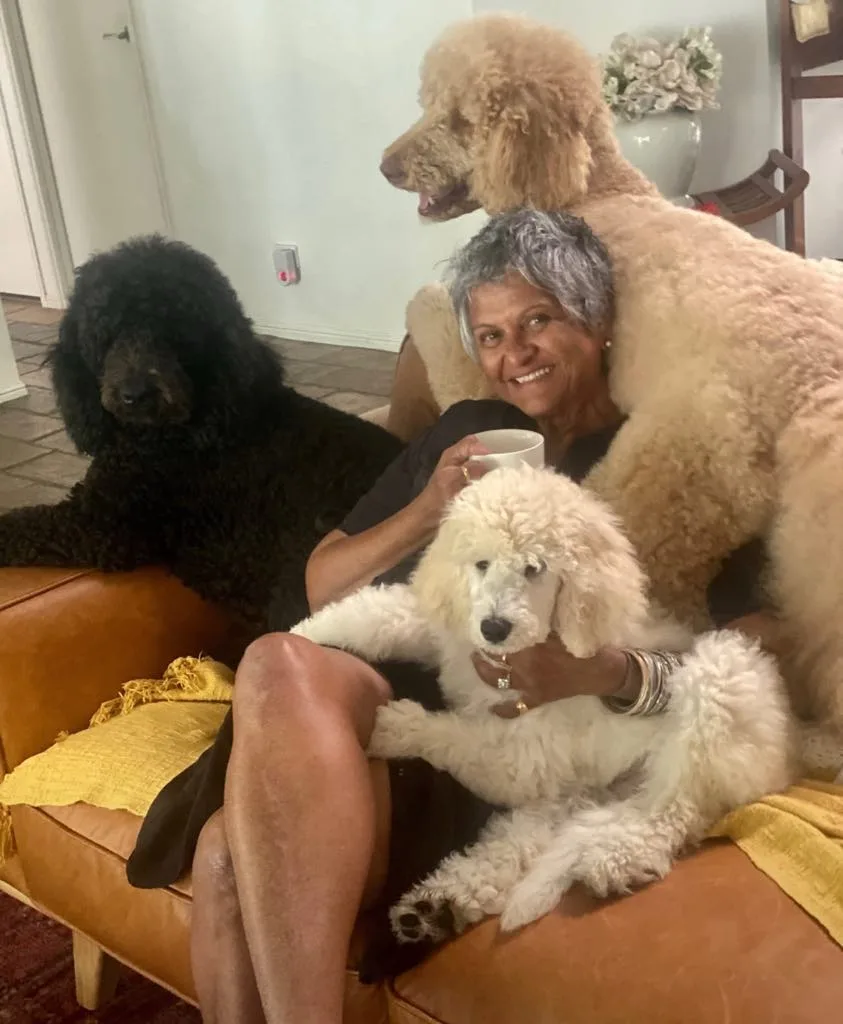 Image of woman and three poodle dogs