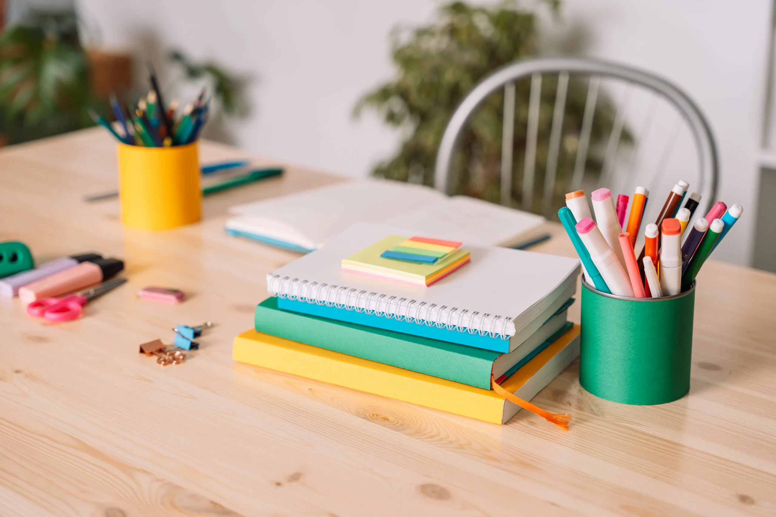 School desk with school supplies against a white wall