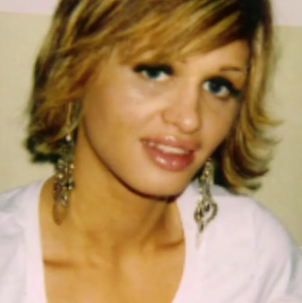 Woman with blonde hair and blue eyes, smiling at camera.