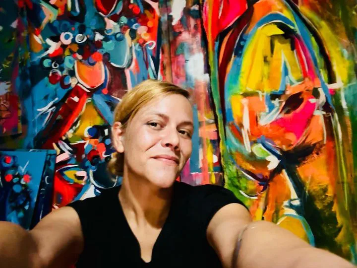Image of woman smiling with artwork
