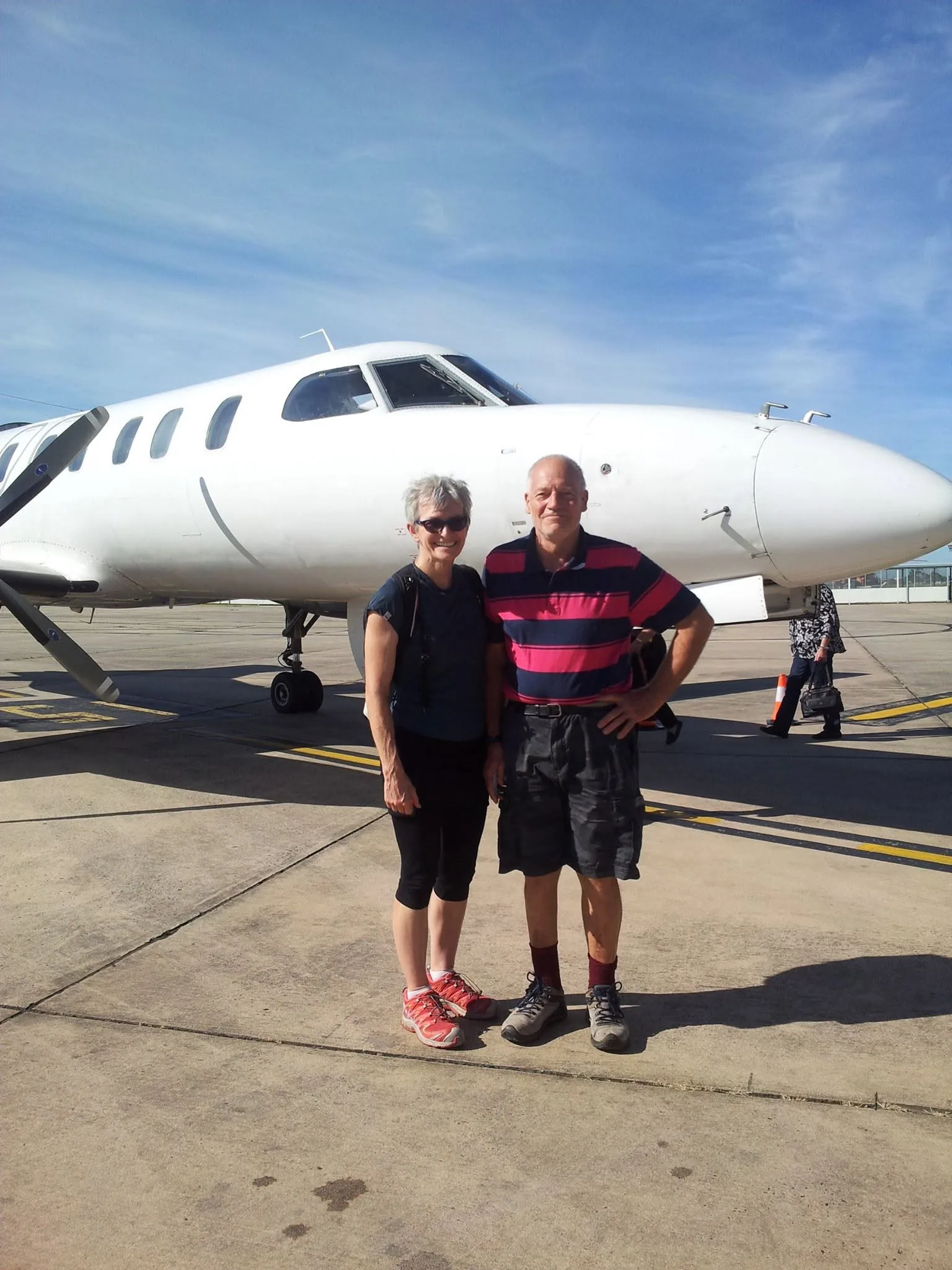 couple in front of plane
