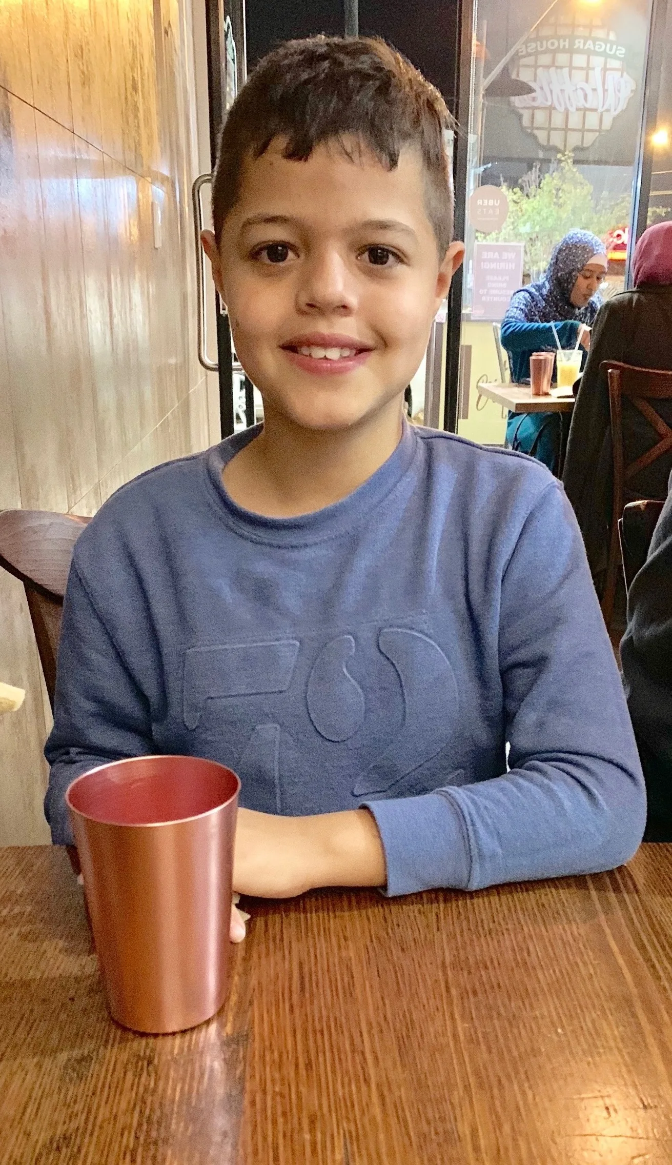 young boy drinking from cup 