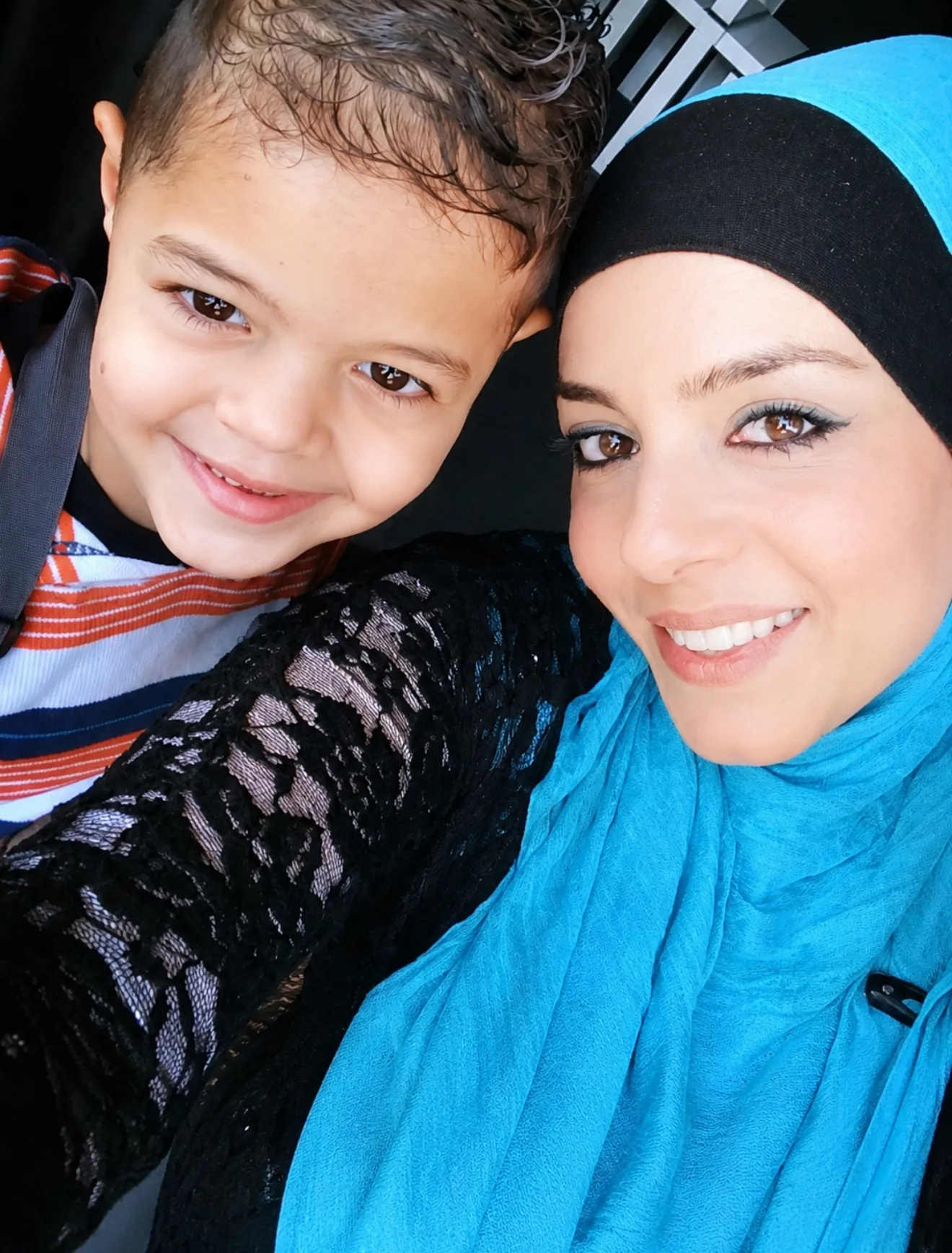 woman wearing blue, young son smiling for camera 