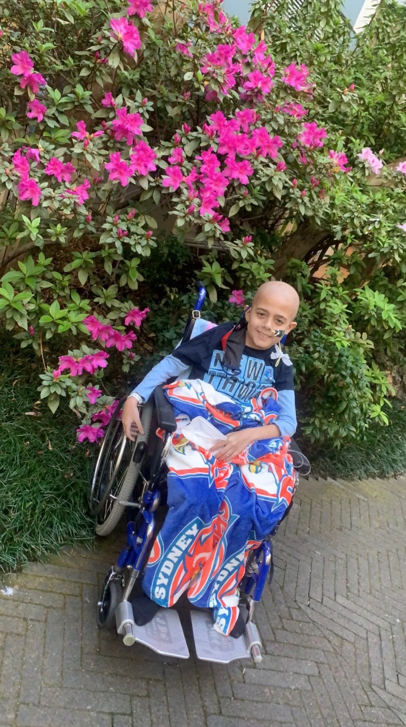 young boy in wheelchair with blanket on knees