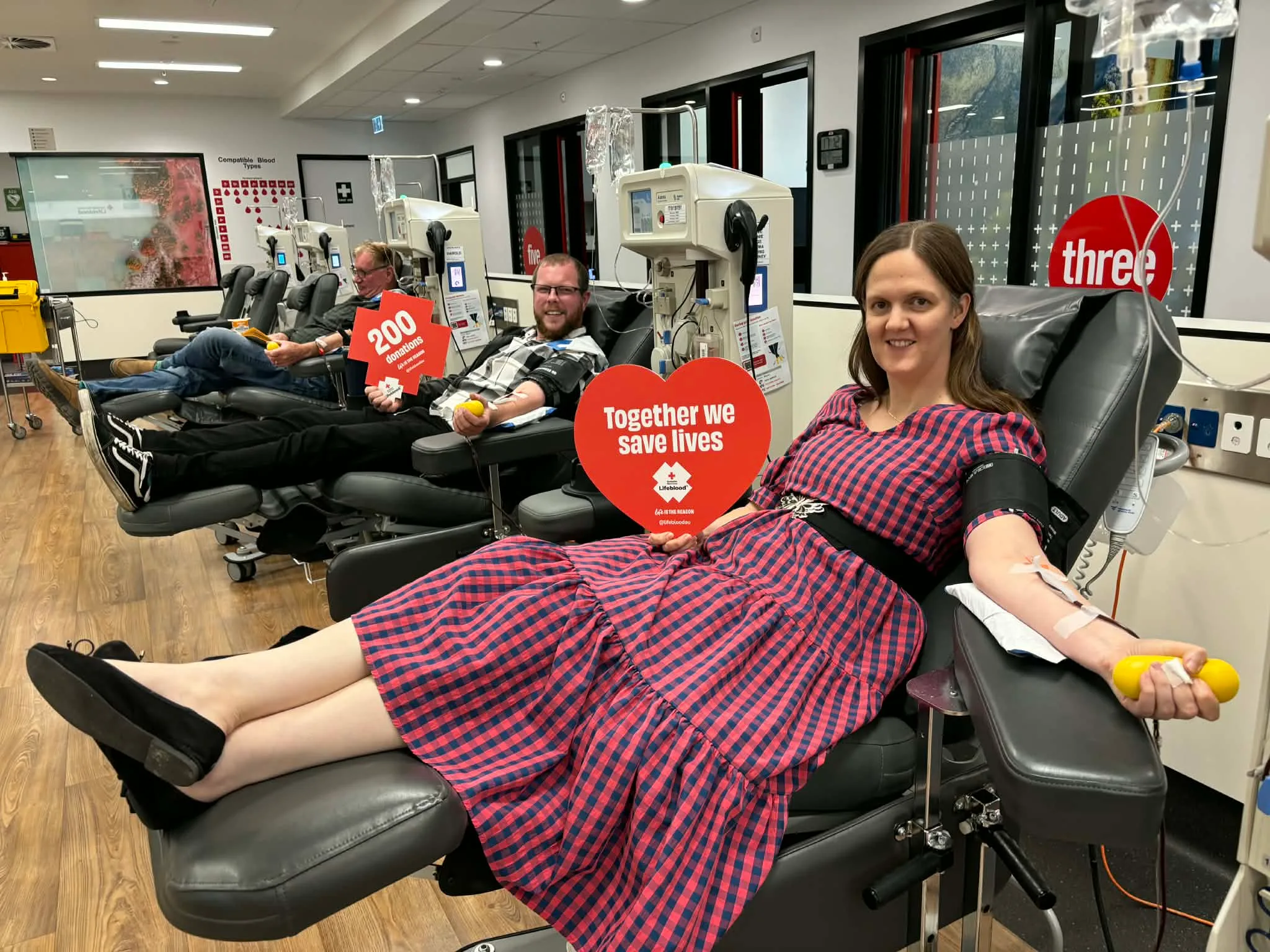 woman in checked dress and man giving blood