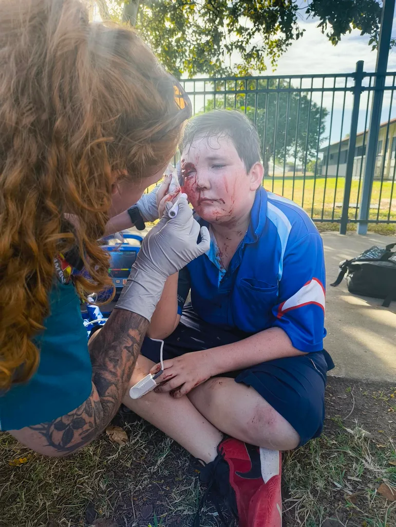 Image of school boy being treated by paramedics after