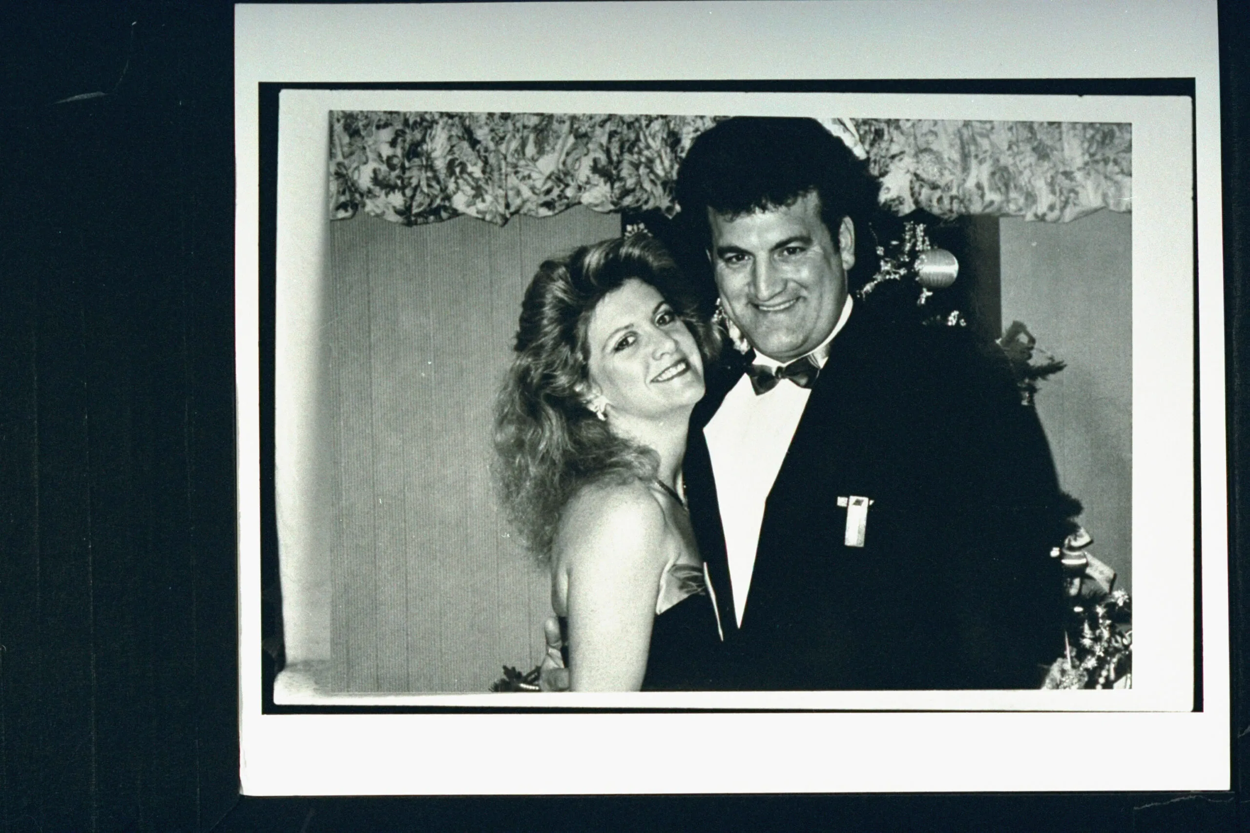 Woman with blonde hair smiling next to man in black suit.