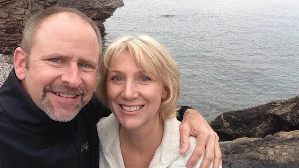 man and woman smiling on cliffs
