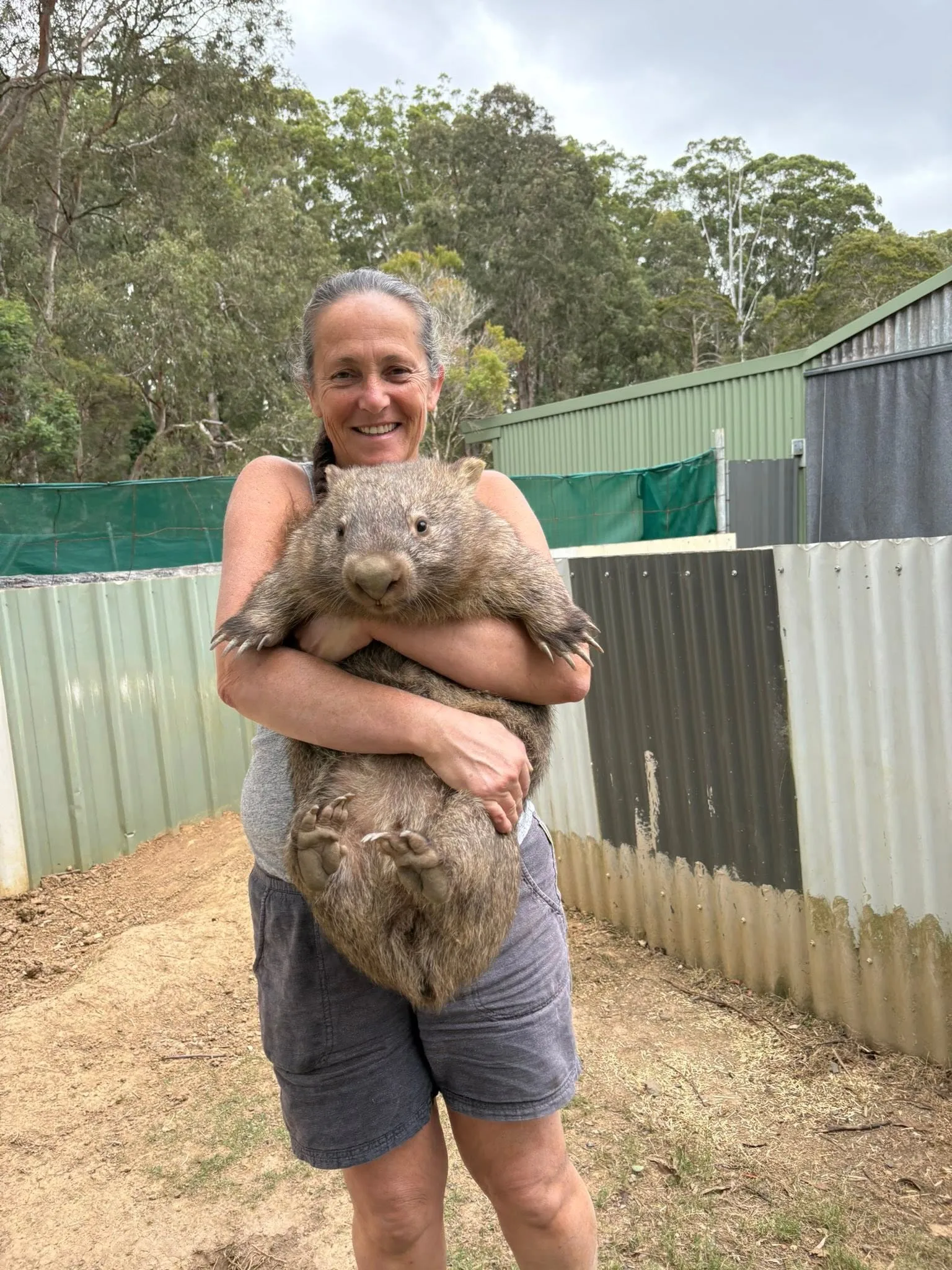 Image of woman carrying wombat