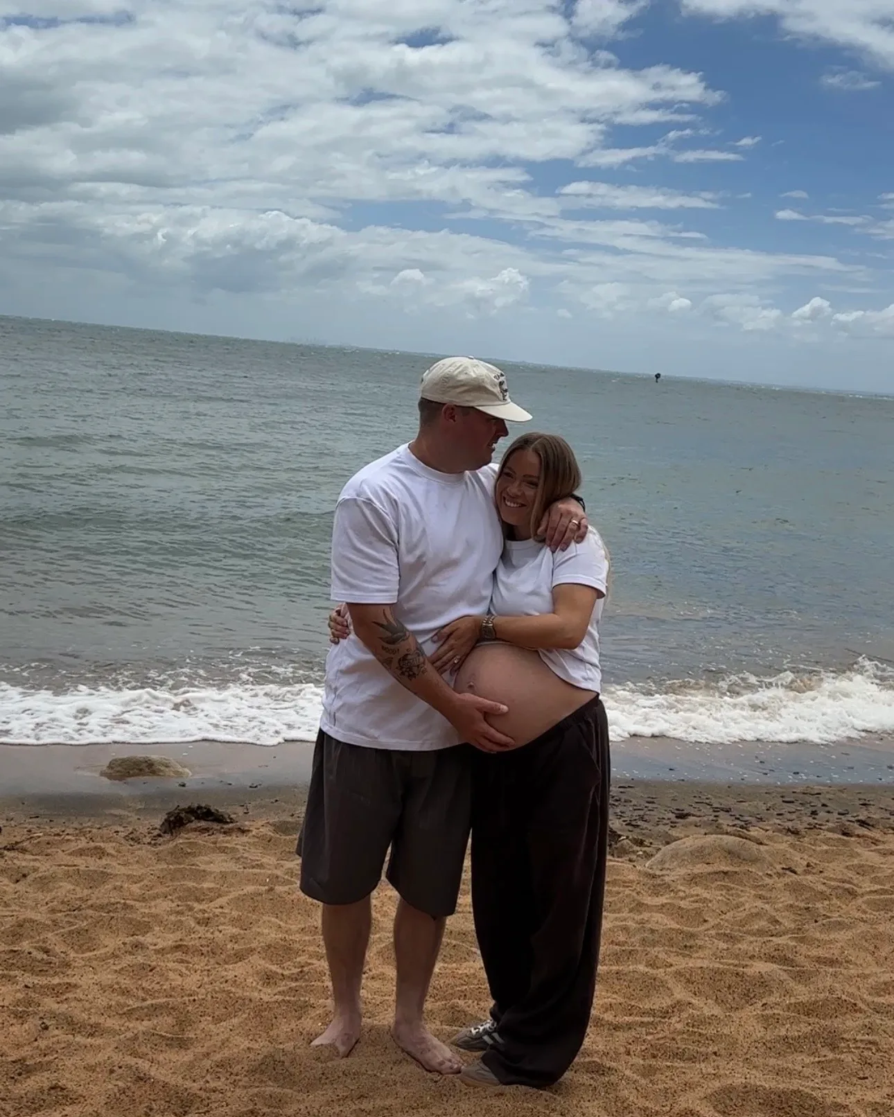 couple on beach pregnancy shoot