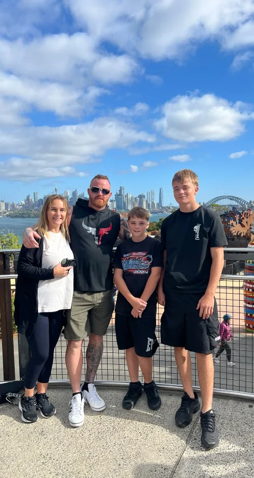 Image of family of four standing in front of sydney harbour bridge