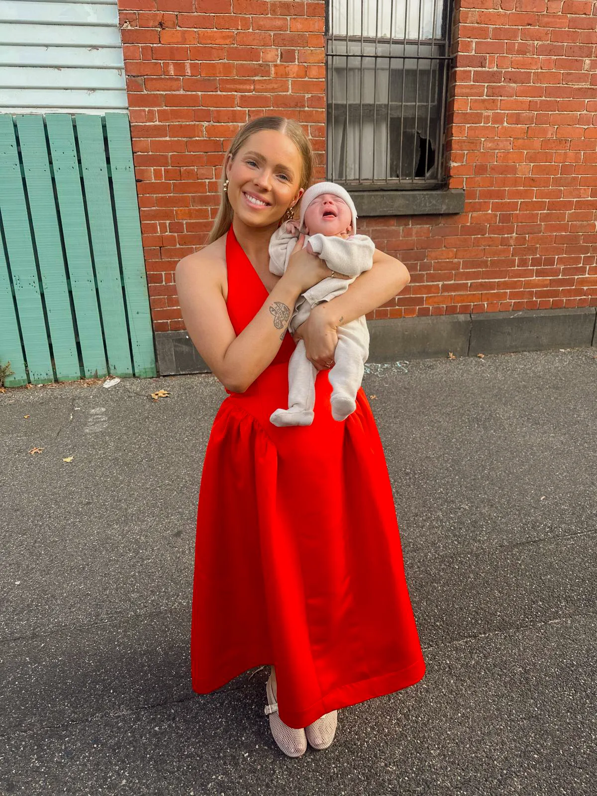 woman in red dress holding baby 