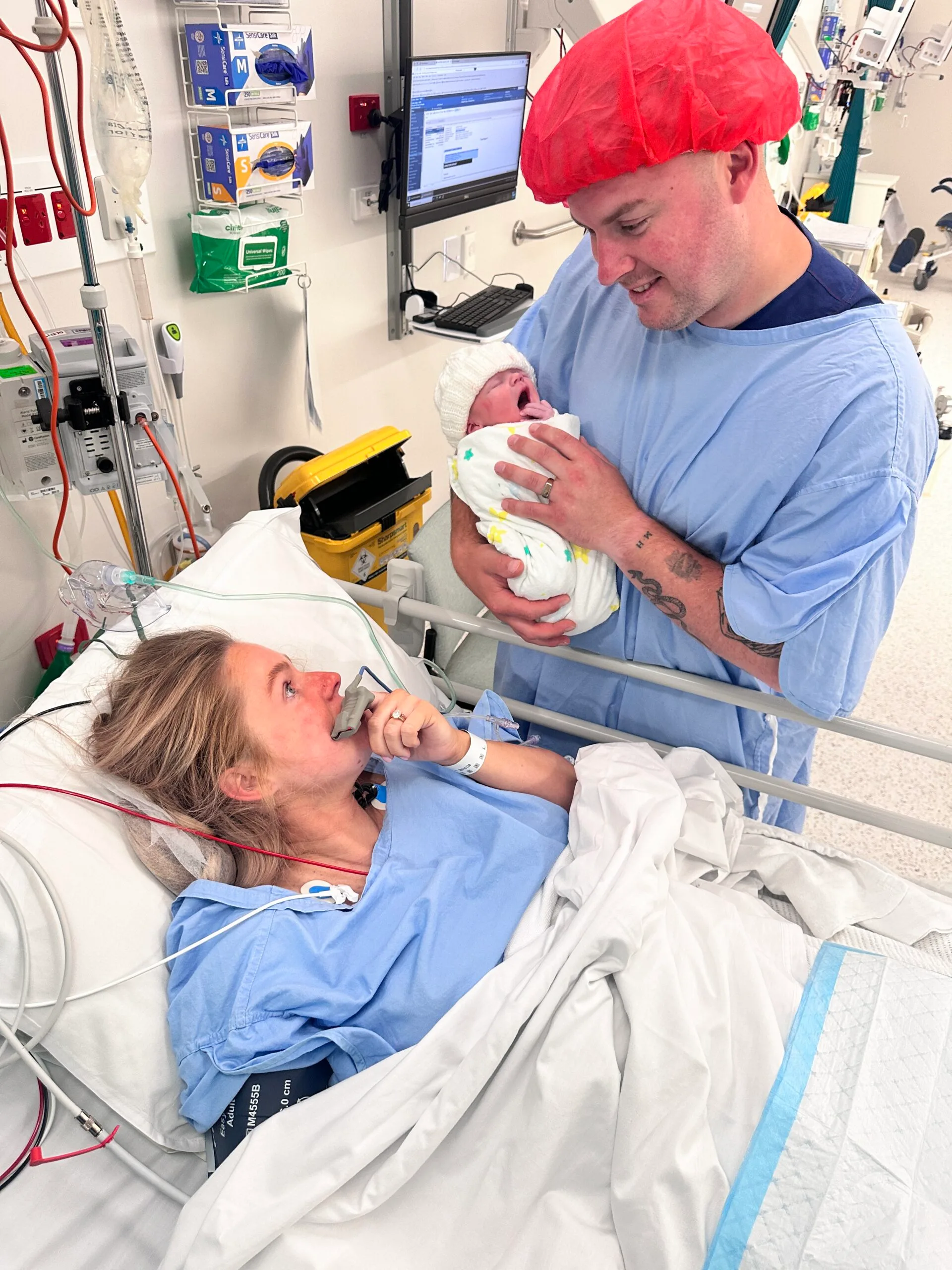 woman with dad holding baby in hospital