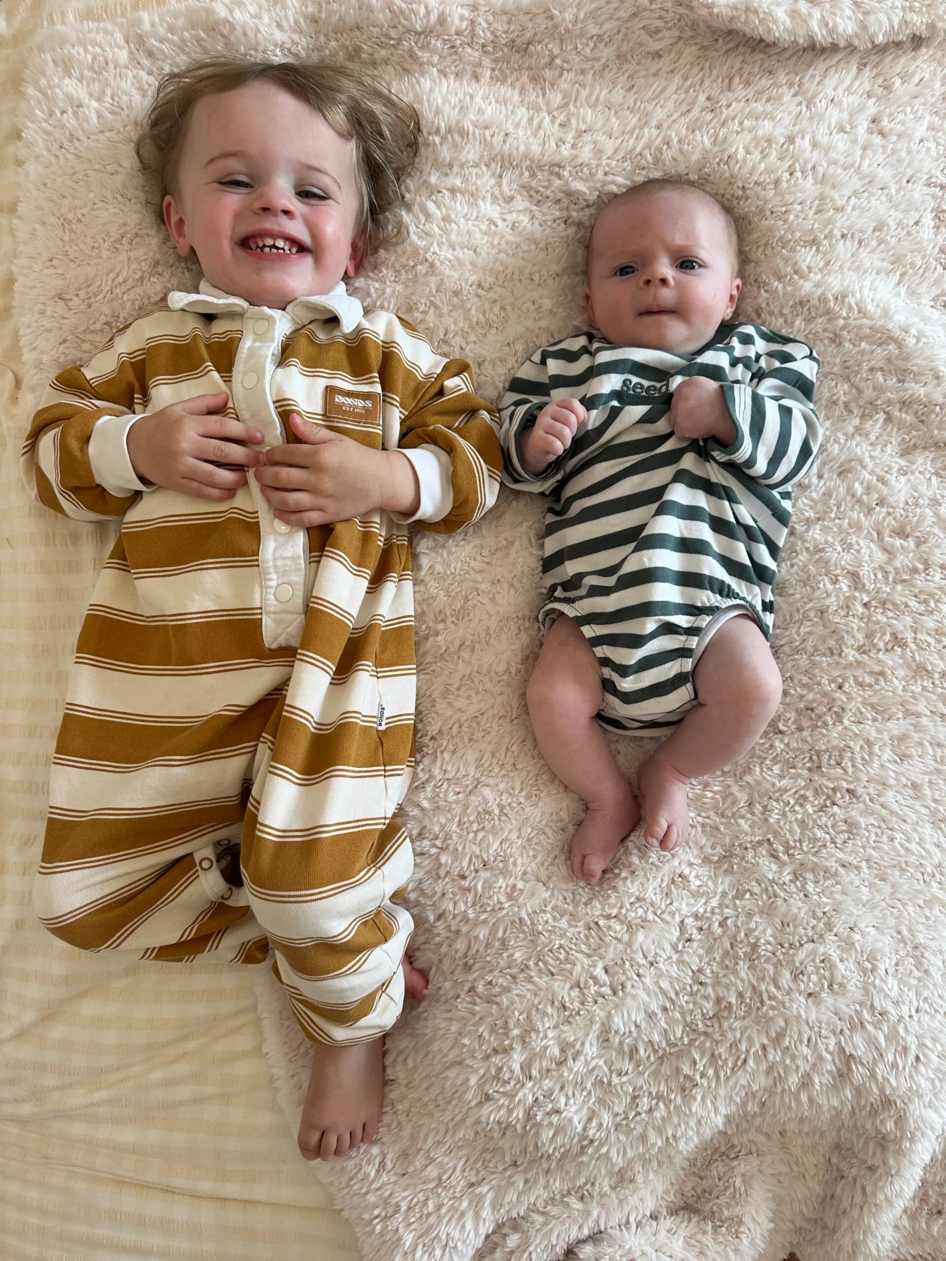 toddler and baby on rug