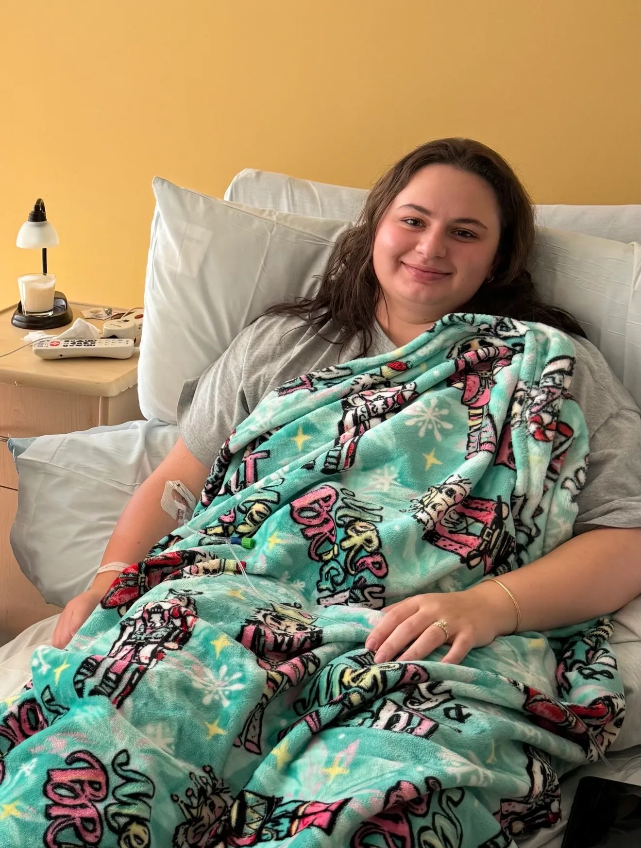 Woman in hospital bed smiling at camera. 