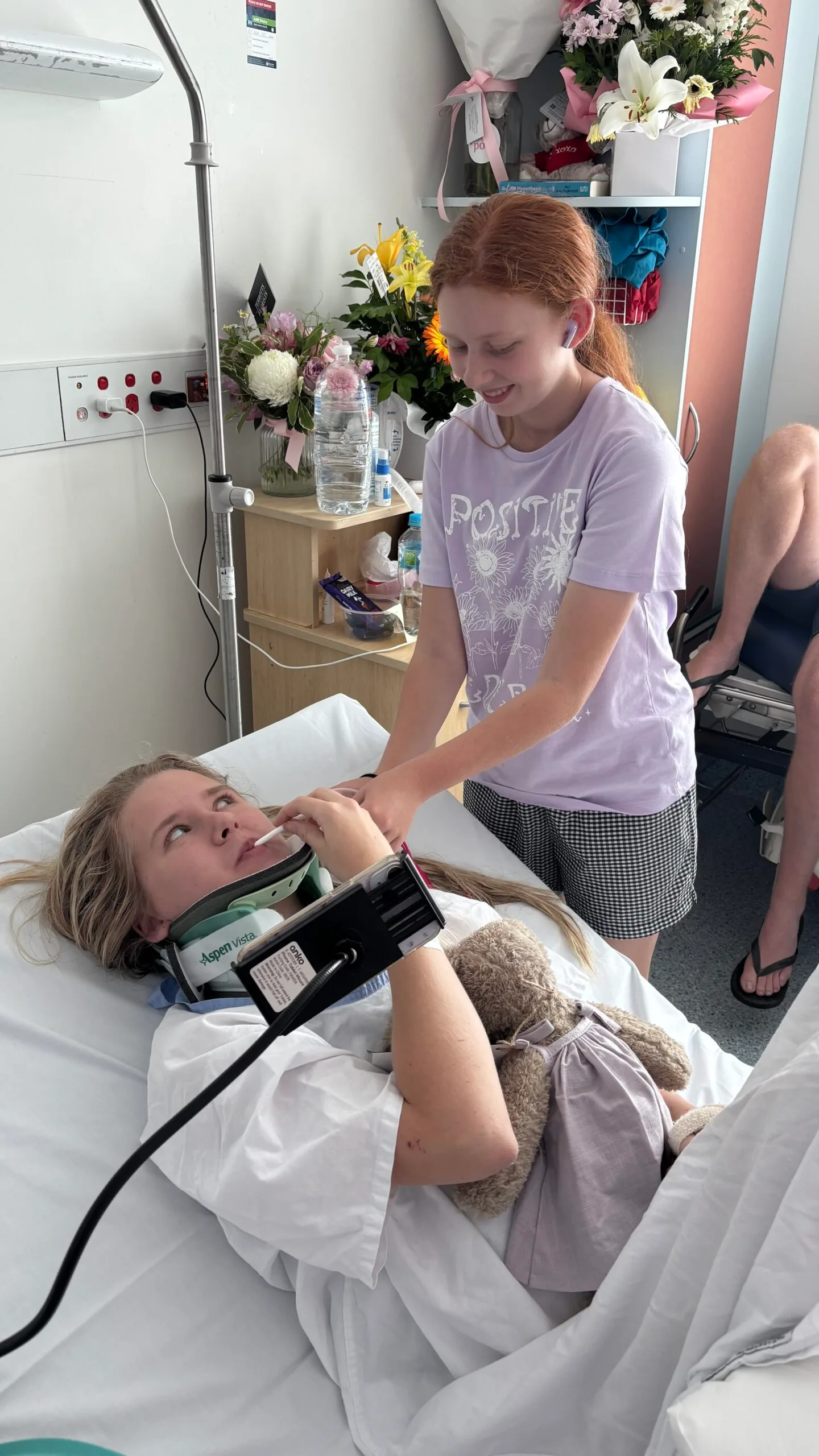 sister helping girl in hospital bed
