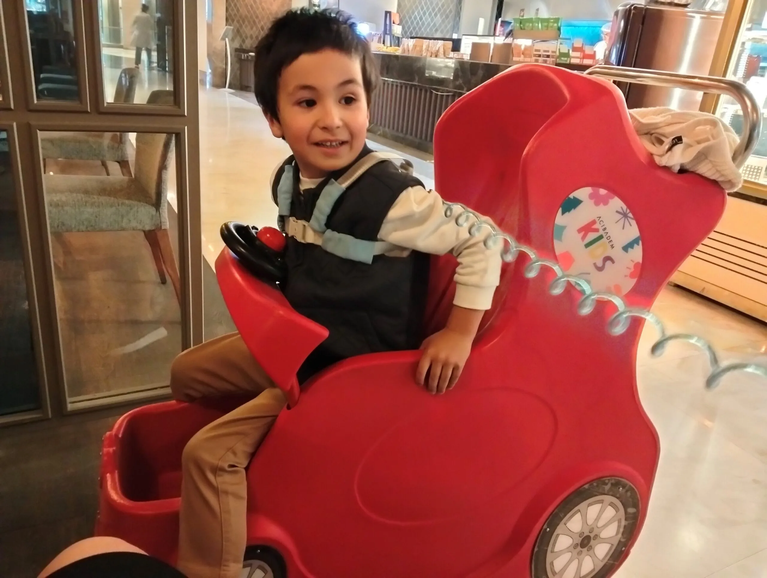 boy in red toy car