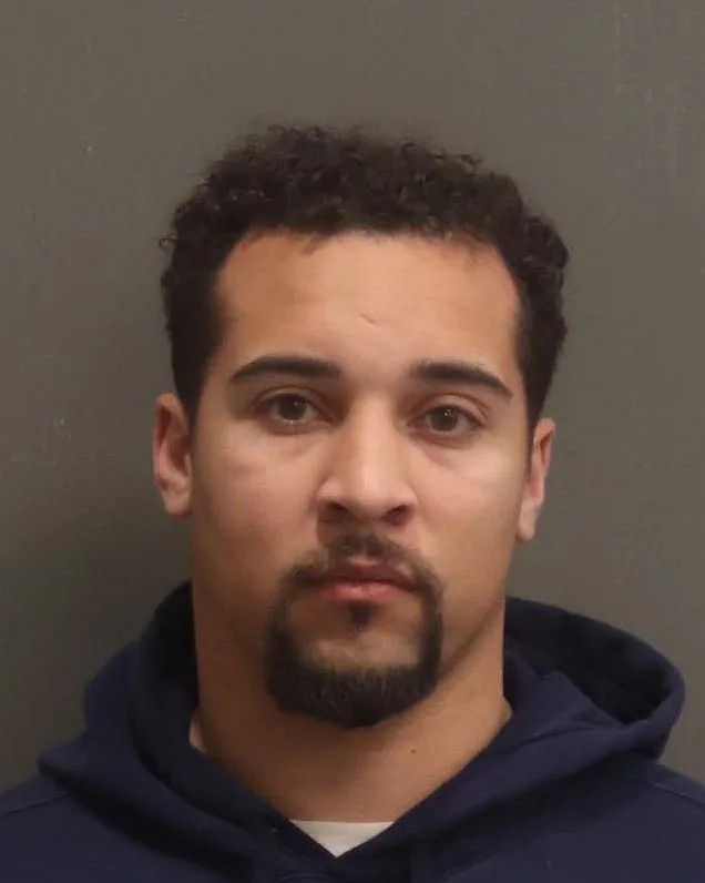 Mugshot of man wearing blue hoodie.