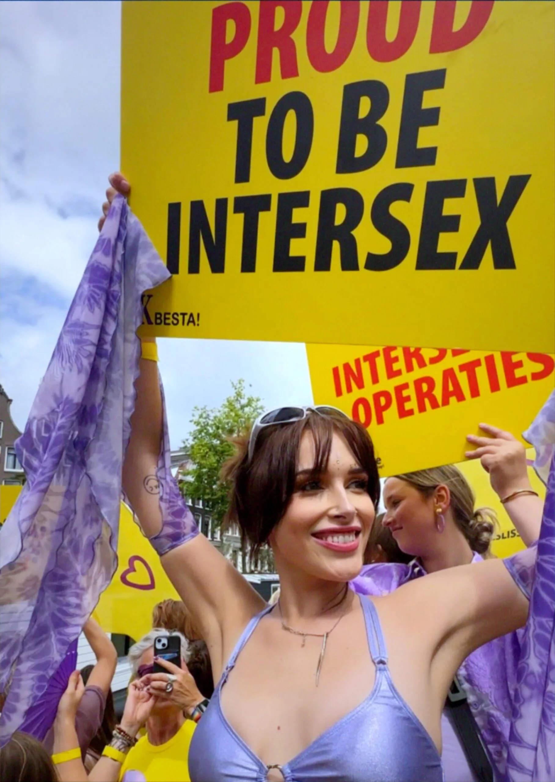 person on boat holding sign that reads 'proud to be intersex'