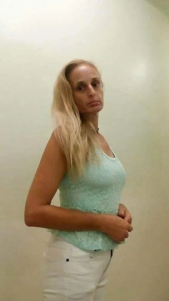 woman in teal top white pants
