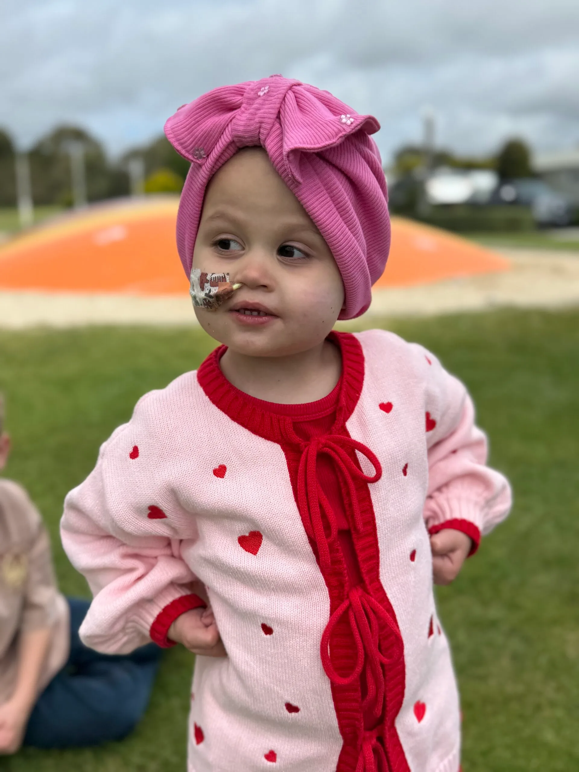 little girl in pink jumper with red hearts