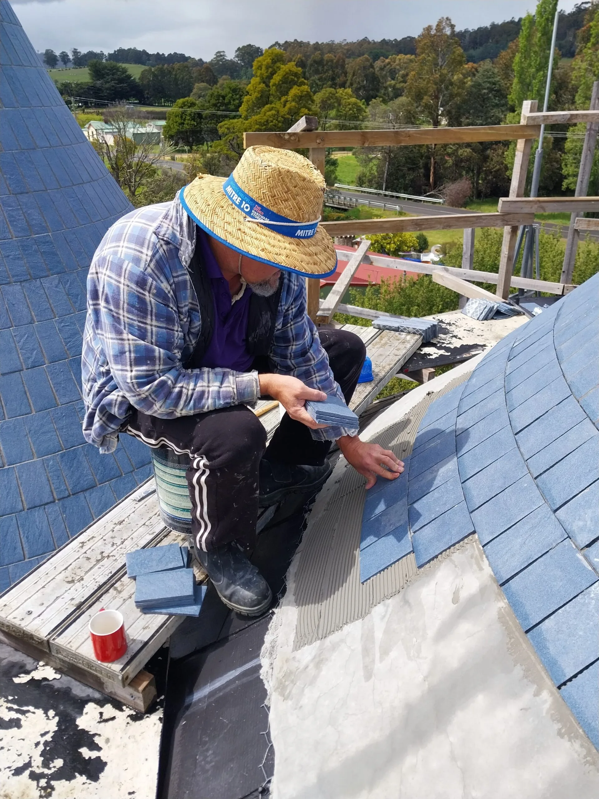 man tiling roof