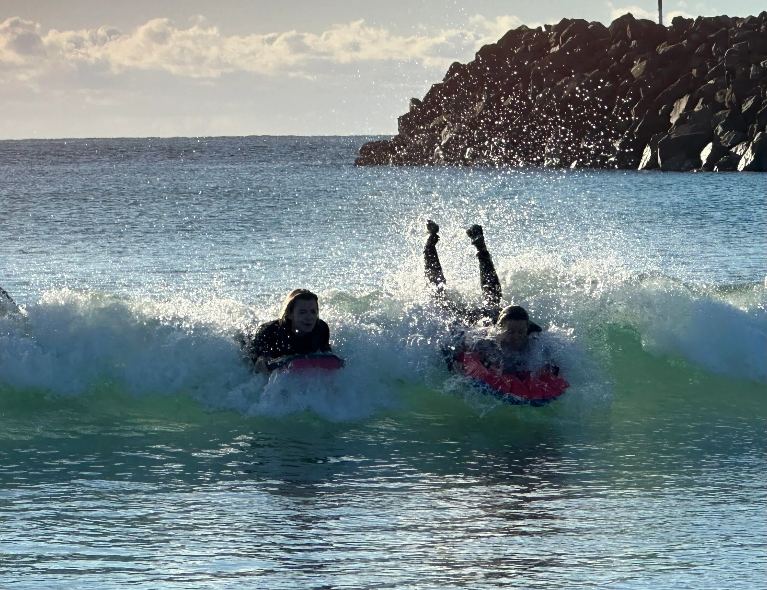 Two women on surfboards in the ocean.