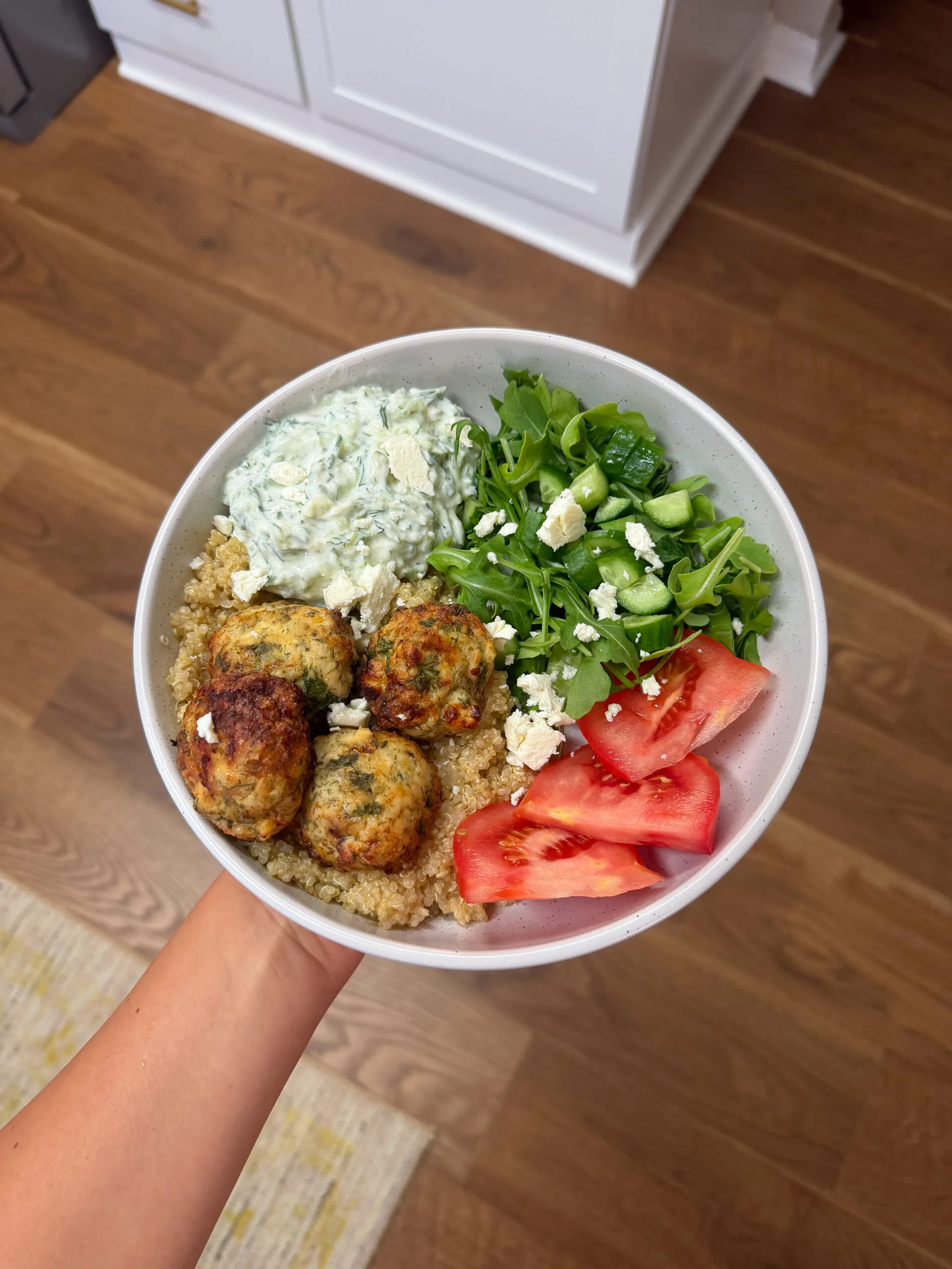 Bowl of greek yogurt, couscous, meatballs and salad.