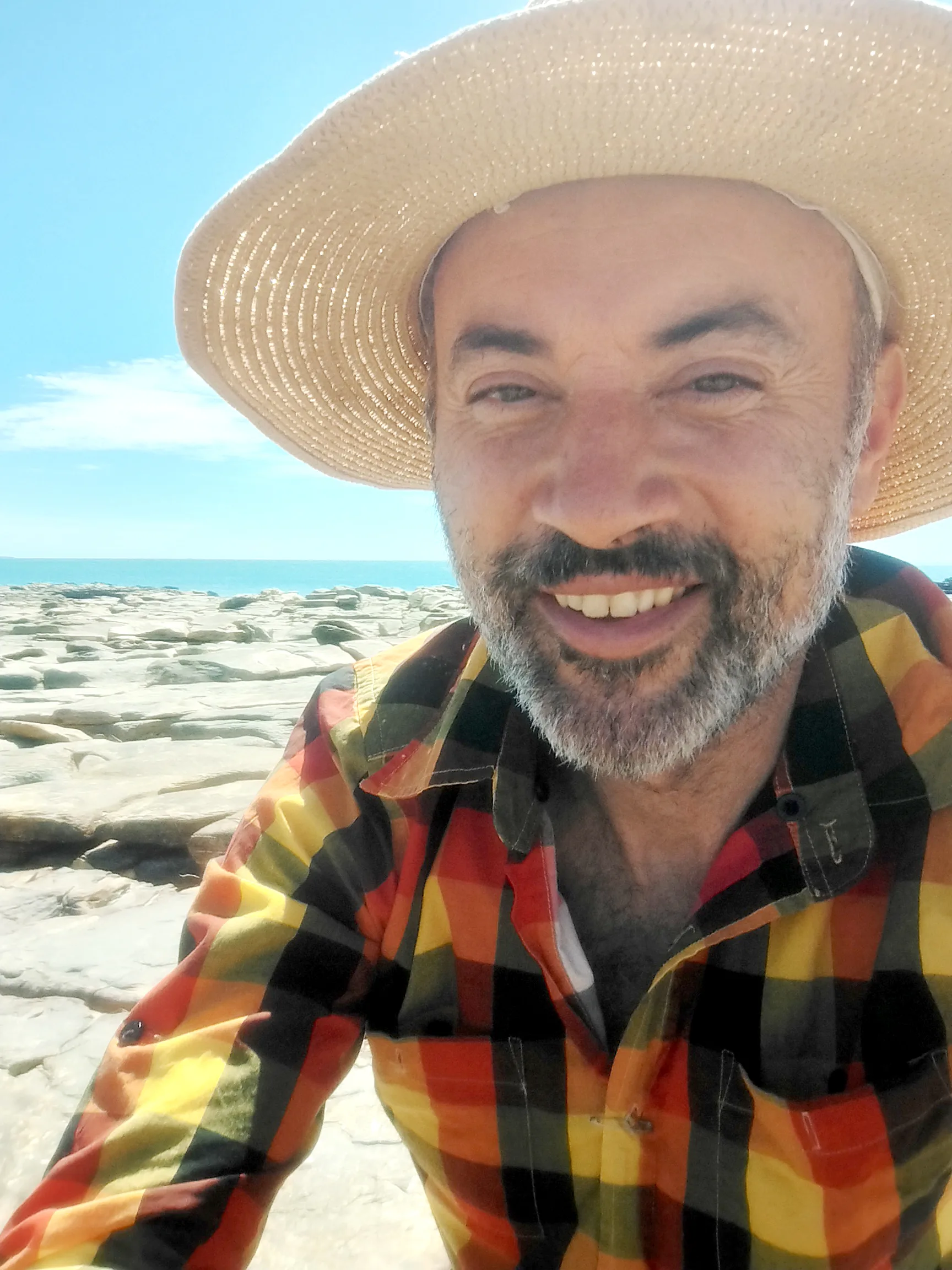 Man in bright checked shirt and sun hat