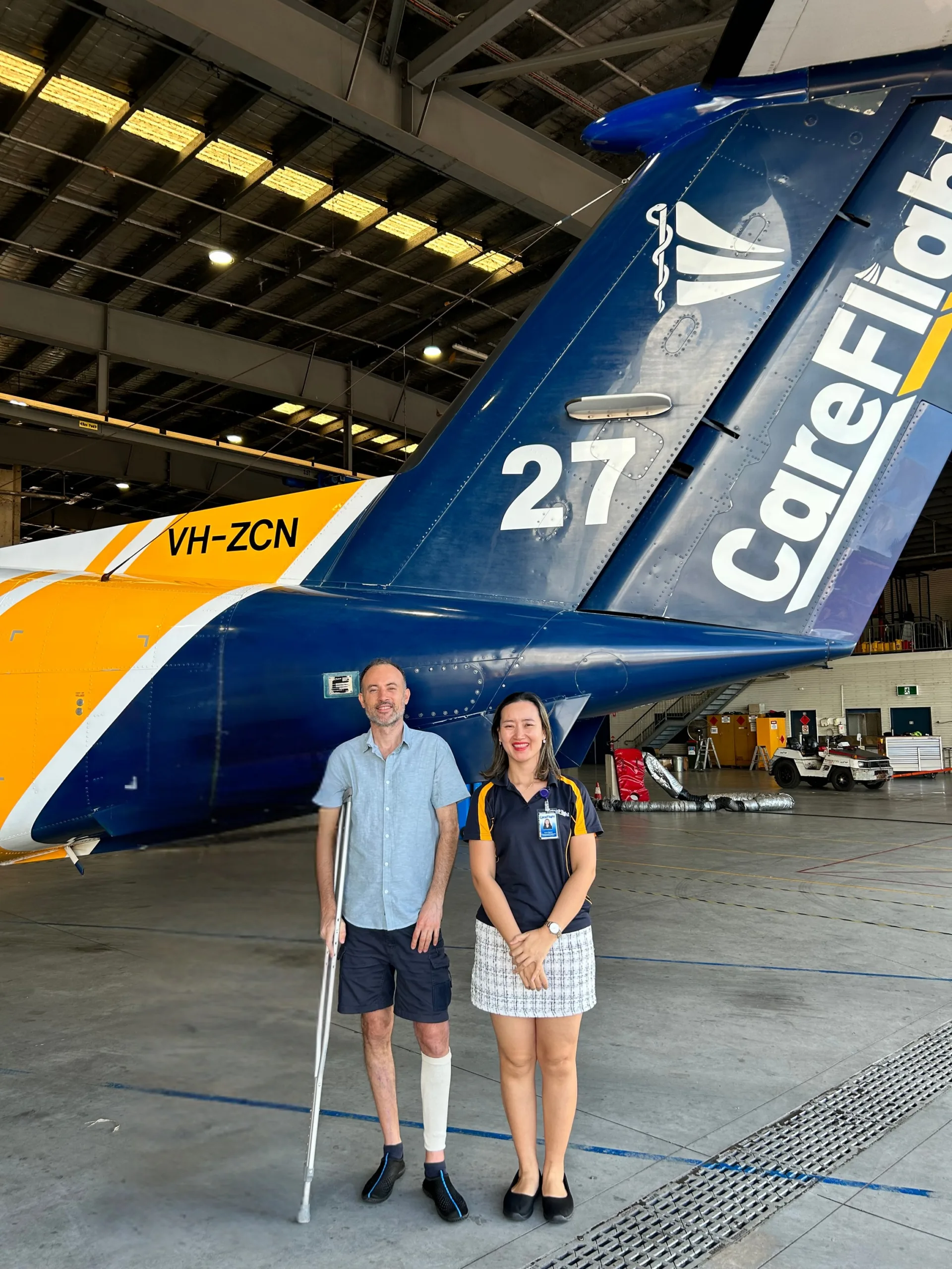 man in aircraft hanger on crutches