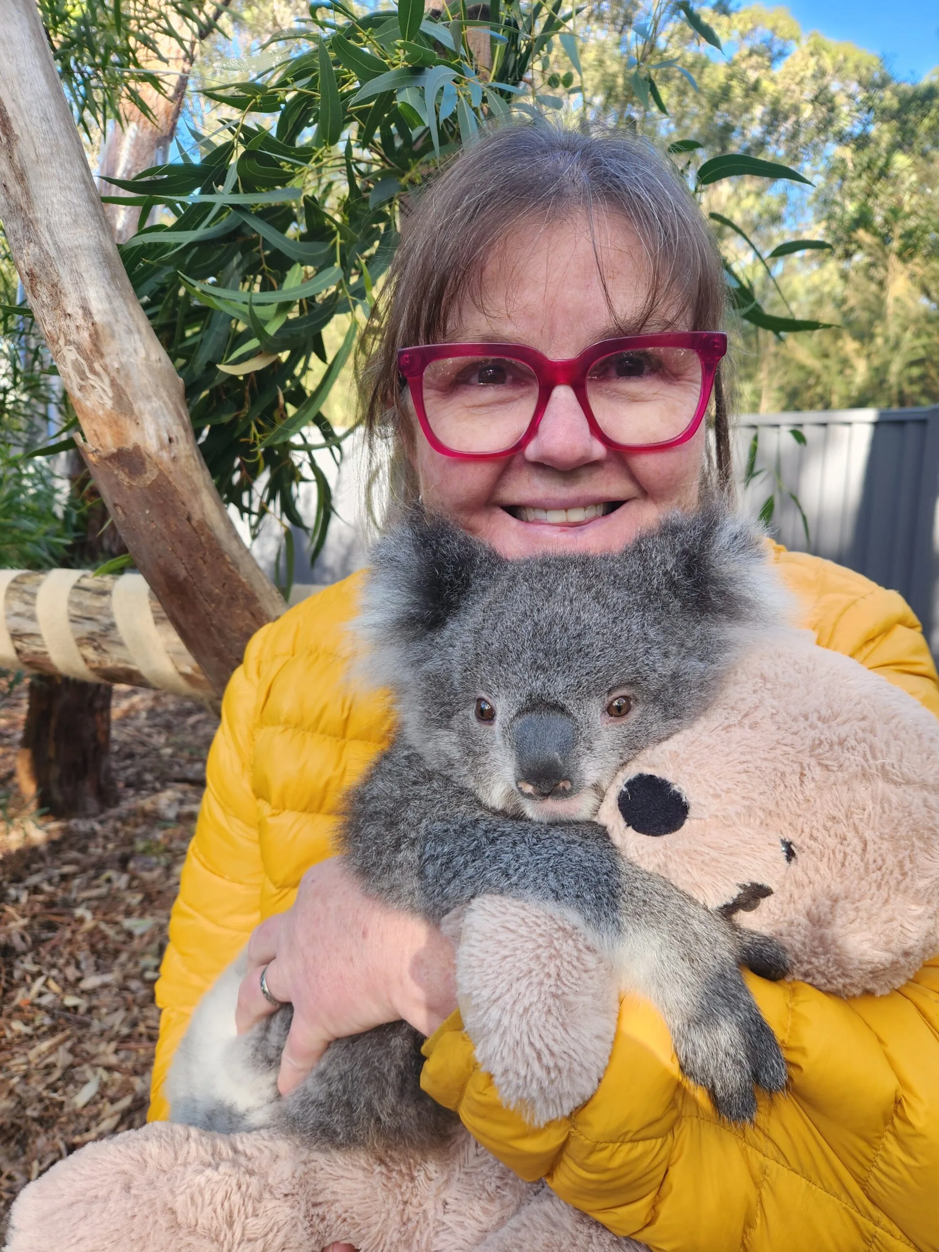 woman in yellow puffer coat with koala 