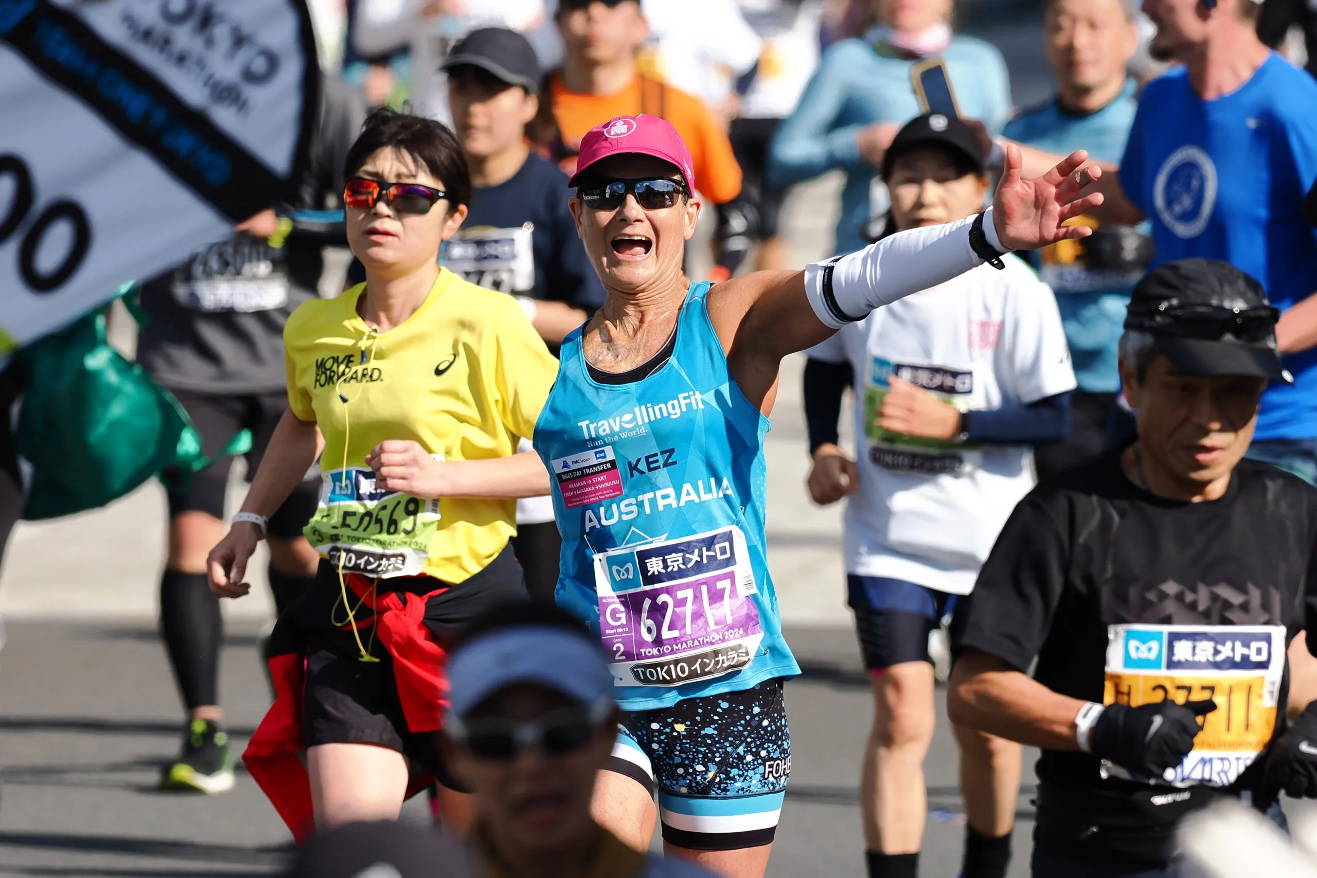 Woman with one arm running alongside multiple people smiling at camera.