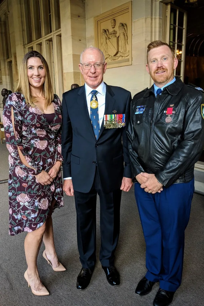 Sergeant Luke Warburton receiving a Bravery Medal with his wife Sandra and the NSW Governor