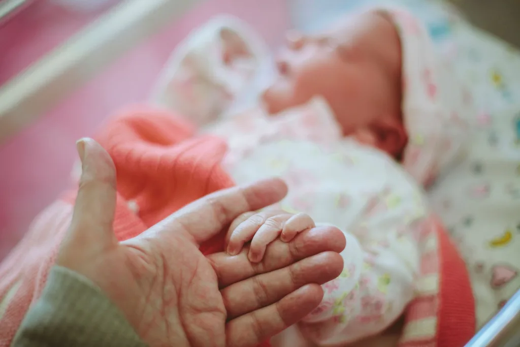 Newborn holding mum's hand