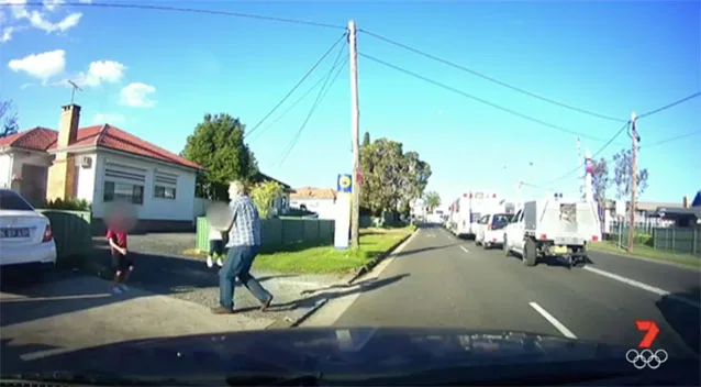 Gary picks the little girl up to move her off the road.